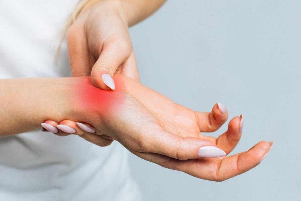 Person holding a painful wrist in an illustrative photograph